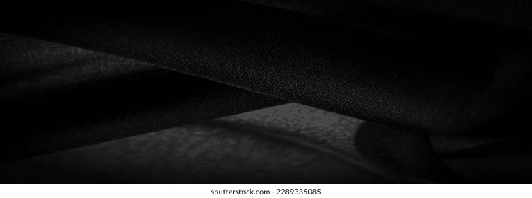 Dark black chiffon silk is a soft transparent fabric with a slight roughness (matte, creped) due to the use of twisted yarn. Background texture