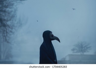 Dark Black Figure Of A Man In A Mask Of Plague Doctor Stands In Fog Twightlight