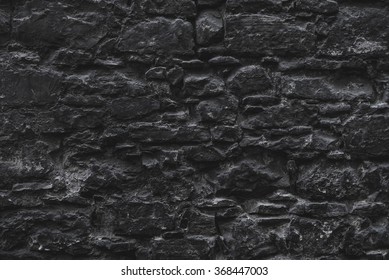 Dark Black Old Medieval Natural Stone Wall. Texture, Background Or Wallpaper