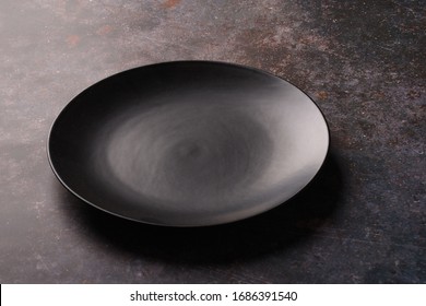 Dark Black Plate On A Dark Tabletop Surface