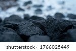 Dark black volcano rocks on the floor with blue background in winter