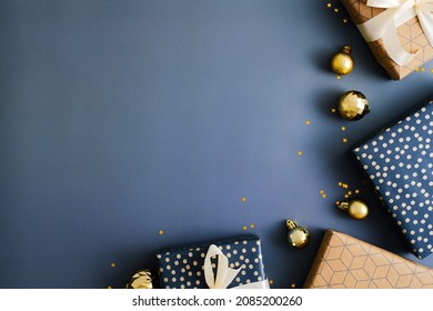 Dark Blue Christmas Background With Gift Boxes And Gold Baubles. Flat Lay, Top View, Copy Space.