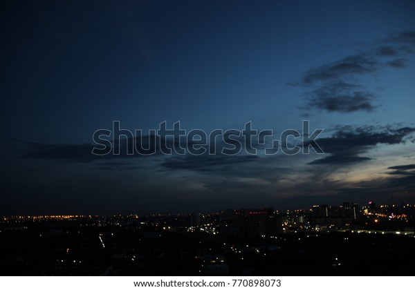 白い明るい空の背景に暗い青い雲と都市の明るい夜の時間 の写真素材 今すぐ編集