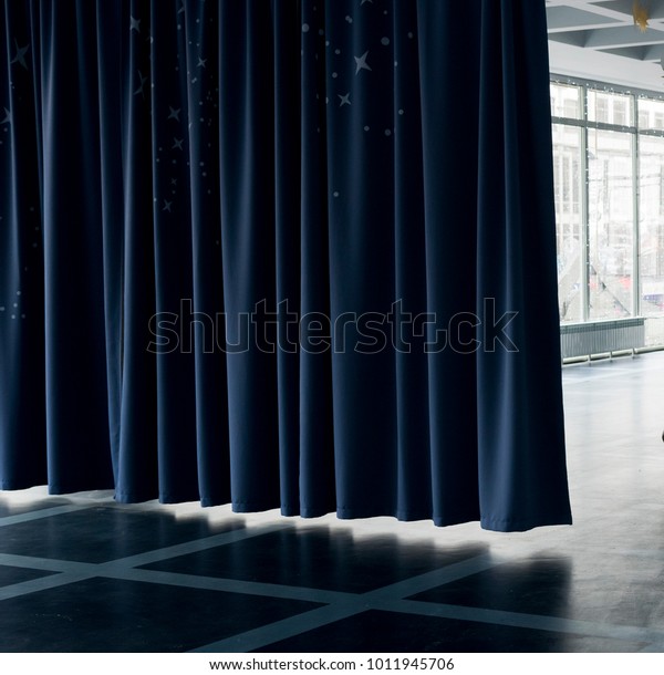 Dark blue curtain dividing\
the room