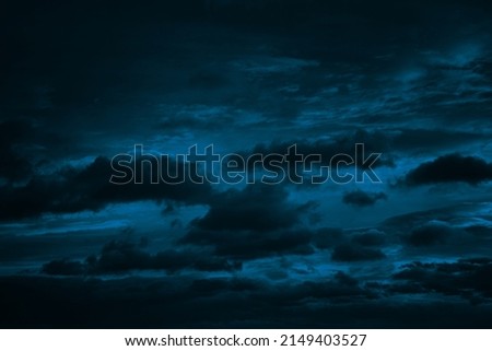  Dark blue green sky with clouds. Dramatic night sky. Moonlight. Toned background with space for design.                              