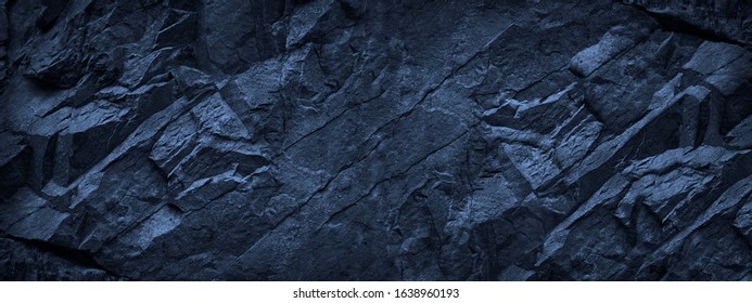 Dark blue grunge background. Deep blue stone background. Toned mountain texture close-up. Banner with copy space for your design. Volumetric rock background.