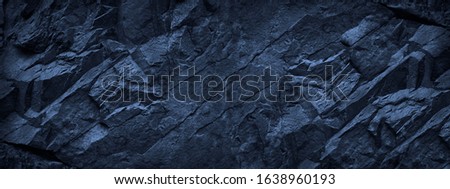 Dark blue grunge background. Deep blue stone background. Toned mountain texture close-up. Banner with copy space for your design. Volumetric rock background.