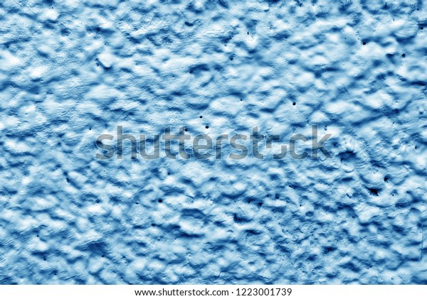 Dark blue relief wall of the house. Dirty shabby\
wall with putty. Relief paint is dark blue. The wall paint is like\
clouds and sky. View of the mountains and craters of the moon from\
a bird\'s-eye view
