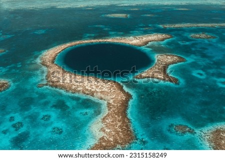 dark blue shallow tropical Caribbean sea with the reef and small white waves in bright sunshine at the Blue Hole on the Belize Barrier Reef  