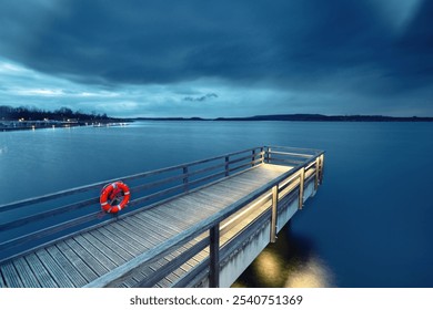 dark blue sky in the evening over a wooden footbridge with red lifebuoy - Powered by Shutterstock