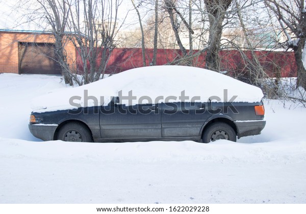 \
Dark blue snow\
covered car, abandoned\
car