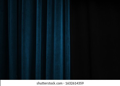 Dark Blue Velvet Curtain On One Side Of A Black Theatre Stage, Event Background Concept With Large Copy Space