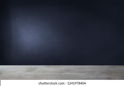 Dark blue wall in an empty room with a concrete floor