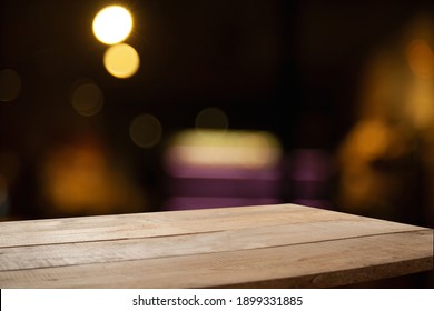 Dark Blurred Cafe Background With Empty Table Top For Your Display