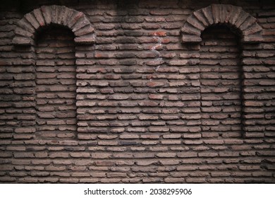 Dark Brick Factory Wall With Two Rounded Sealed Windows