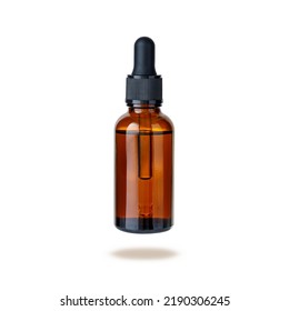 Dark brown amber glass bottle of face serum or essential oil or pharmaceutical tincture flying isolated on white background - Powered by Shutterstock