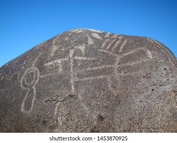 Dark Brown Boulder With Historical Archaeological Petroglyph Rock Carvings At Celebration Park In Idaho.