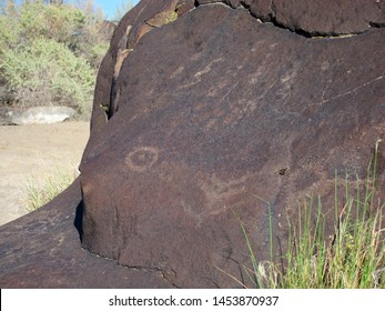 Dark Brown Boulder With Historical Archaeological Petroglyph Rock Carvings At Celebration Park In Idaho.