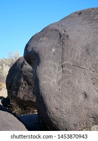 Dark Brown Boulder With Historical Archaeological Petroglyph Rock Carvings At Celebration Park In Idaho.