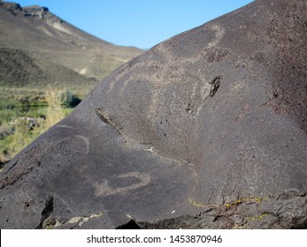 Dark Brown Boulder With Historical Archaeological Petroglyph Rock Carvings At Celebration Park In Idaho.