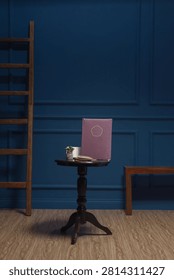 A dark brown folder displayed on a small round wooden table, against a backdrop of classic navy blue wood paneling next to a decorative staircase.