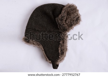 A dark brown herringbone trapper hat with brown faux fur trim on the ear flaps and brim. The hat is shown from a top-down perspective against a white background. trapper hat, ushanka......