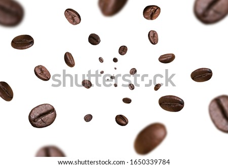 Dark brown roasted coffee beans falling on white background. Concept for coffee product advertising. Selective Focus.