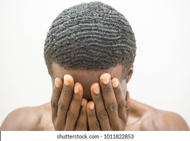 Dark Brown Skin African man covering face with hands in pain shame concept