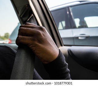 Dark brown skin African woman's hand pulling and wearing safety seatbelt in the car automobile accident safety concept