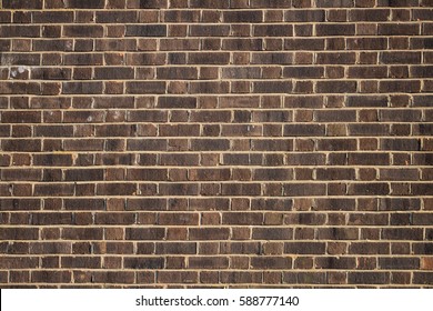 Dark Brown, Yellow Brick Wall With Yellow Cement Background.