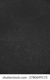 Dark bumpy wall texture creating an abstract rough surface background