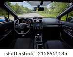 Dark car interior - steering wheel, shift lever and dashboard. Car modern inside. Front view 