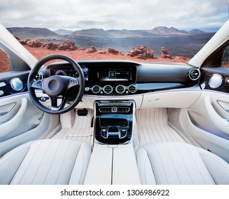 Dark Car Interior - Steering Wheel, Shift Lever And Dashboard. Car Modern Inside. Front View On Sunset And Sea Background. The Sun Shines In The Glass.glare