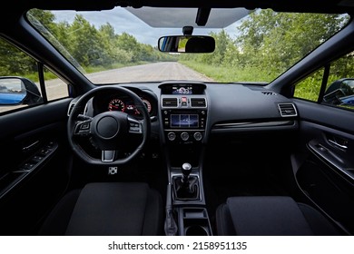 Dark car interior - steering wheel, shift lever and dashboard. Car modern inside. Front view 