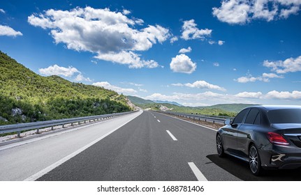 Dark Car On A Freeway In A Beautiful Area.