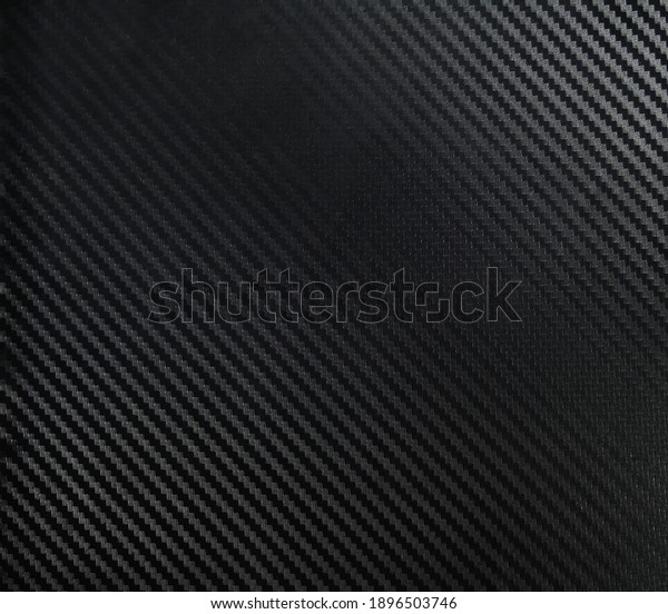A dark carbon fiber\
material shot. A dark industrial texture suitable as a background\
on compositions