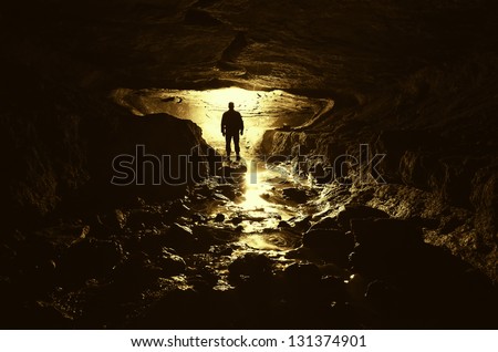 dark cave with man silhouette and water