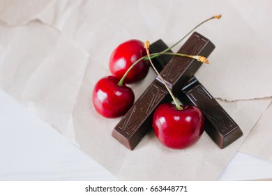 Dark Chocolate With Cherry On Wooden Table.