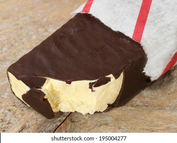 dark chocolate coated ice cream bar in a paper wrapper                         