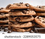 Dark chocolate cookies home made stacked with chocolate chips on a white background