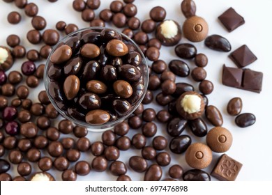 Dark Chocolate Covered Almonds In A Glass Bowl On White Background,top View