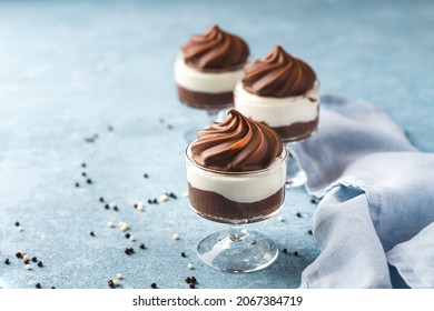 A dark chocolate mousse with white chocolate mousse dessert in a glass with milk chocolate decoration on top - Powered by Shutterstock