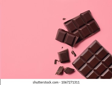 Dark chocolate on pink background. Top view