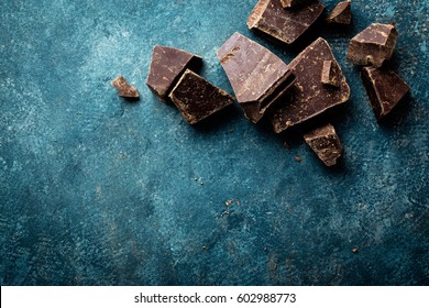 Dark Chocolate Pieces Crushed On A Dark Background, View From Above