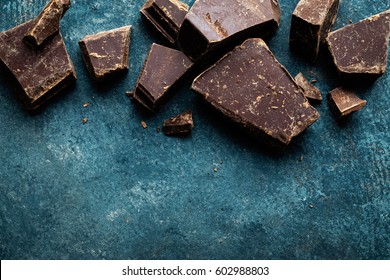 Dark Chocolate Pieces Crushed On A Dark Background, View From Above