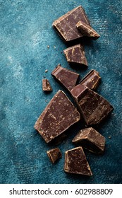 Dark Chocolate Pieces Crushed On A Dark Background, View From Above