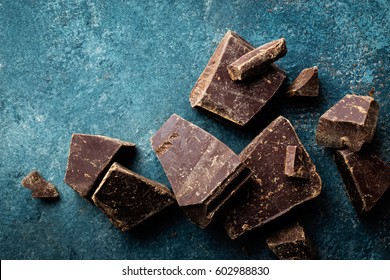 Dark Chocolate Pieces Crushed On A Dark Background, View From Above