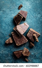 Dark Chocolate Pieces Crushed On A Dark Background, View From Above