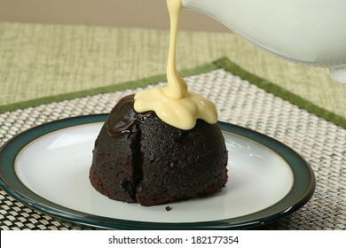 dark chocolate sponge dessert with pouring custard