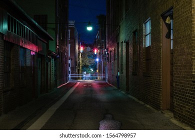dark city ally with long exposure of a car passing by - Shutterstock ID 1564798957